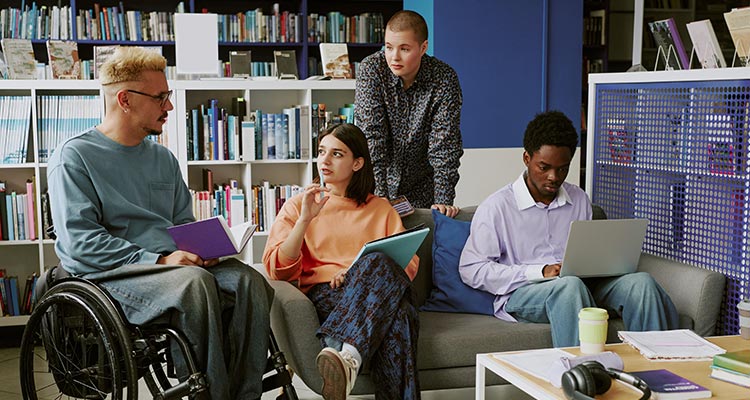student in wheelchair talking with other students